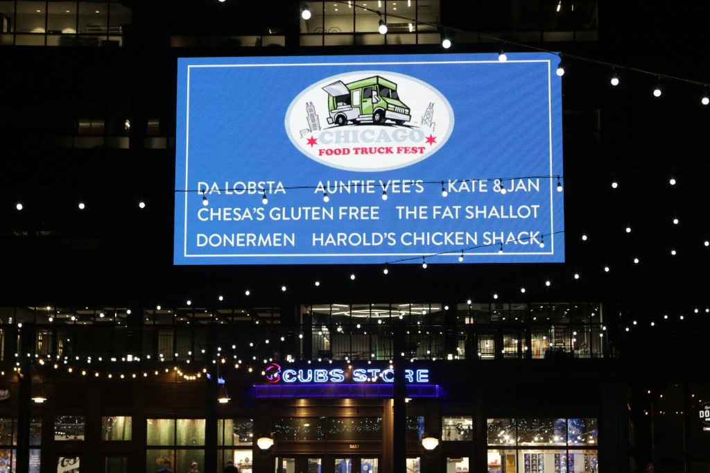 Large screen reading Friendsgiving at the Park presented by Bud Light with string lights in front