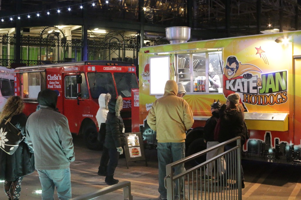 Guitarist and drummer performing under pink stage lights at an outdoor night concert
