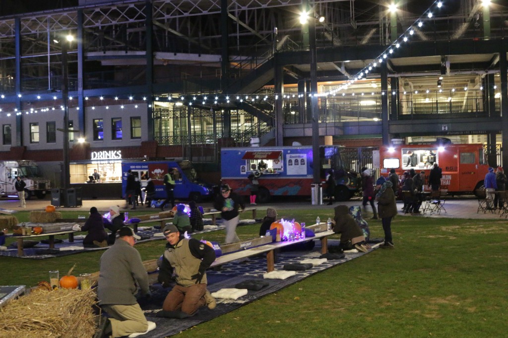 Audience watches the band with Bud Light banner, string lights, and autumn trees at Gallagher Way