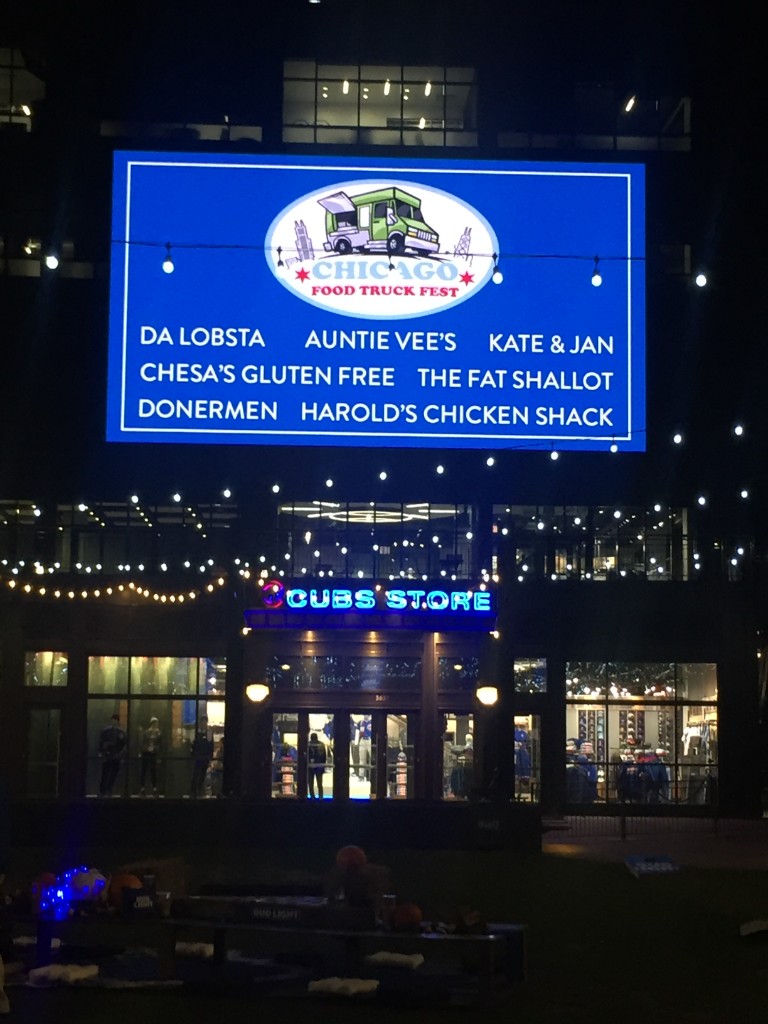 Wide view of the Friendsgiving setup and crowd at The Park at Wrigley after dark
