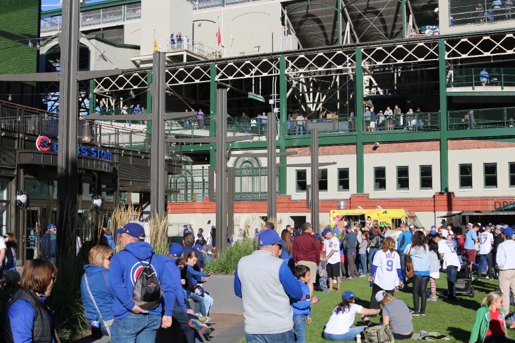 Crowd on Gallagher Way with a food truck outside Wrigley Field during a Cubs home game