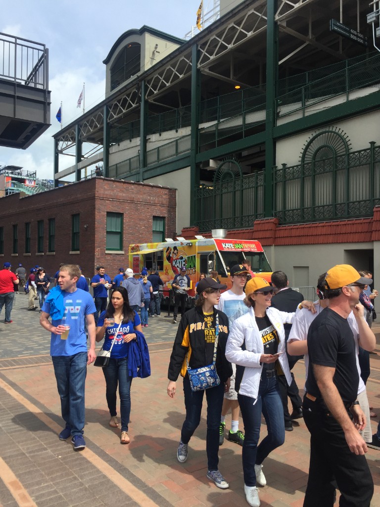 Food trucks and crowds outside Wrigley Field on a sunny Cubs home game day