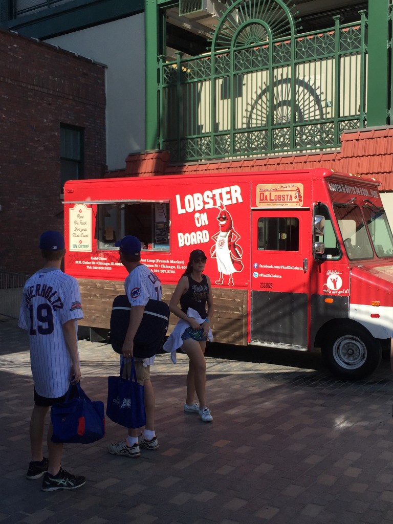 Da Lobsta red lobster truck parked outside Wrigley Field with fans in Cubs jerseys