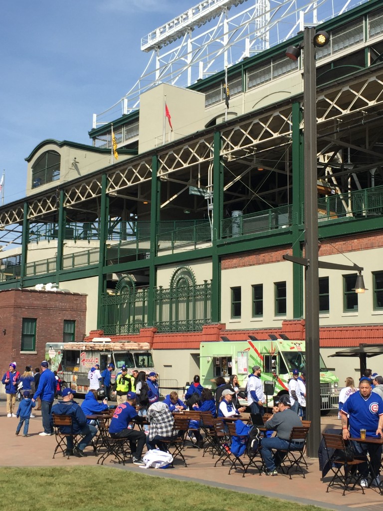Cubs fans at picnic tables near Harold&rsquo;s Chicken and another food truck outside Wrigley Field